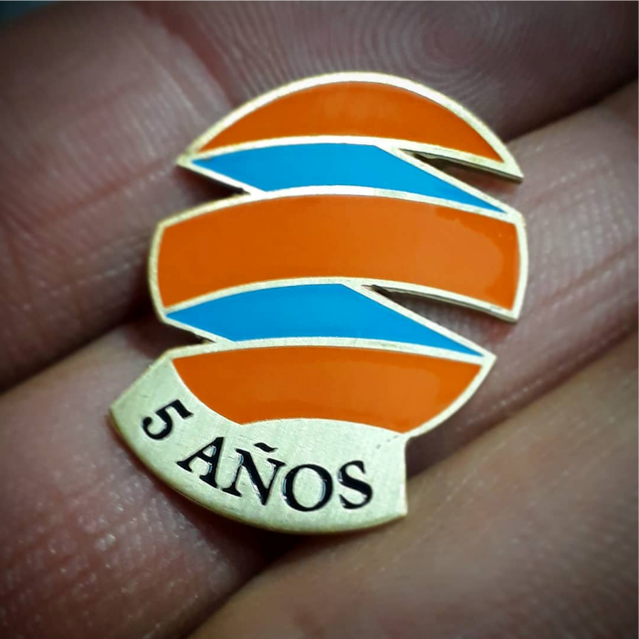 "Pin empresarial bidimensional fotograbado en bronce."