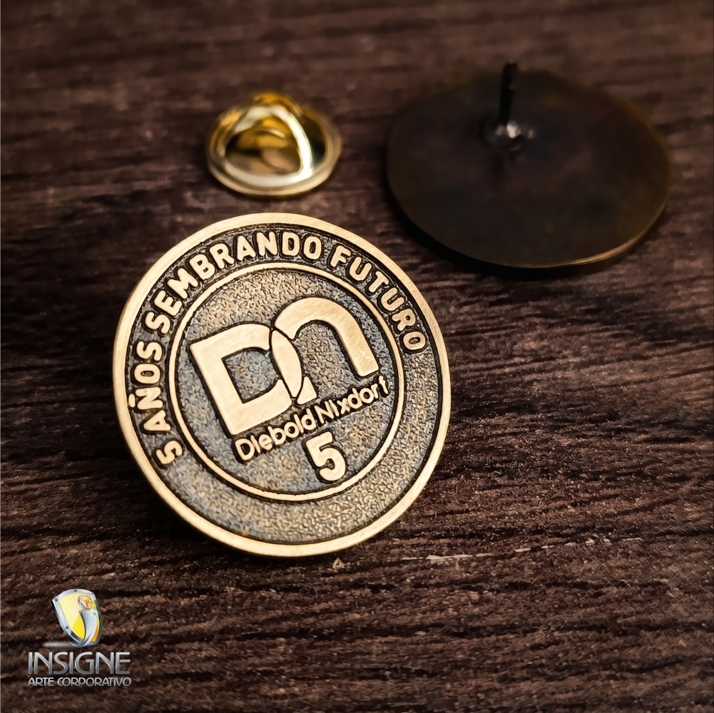 PIN TROQUELADO EN BRONCE ANTIGUO.
